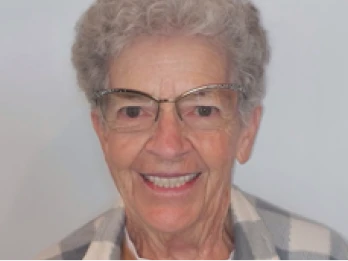 Elderly woman smiling with restored teeth.